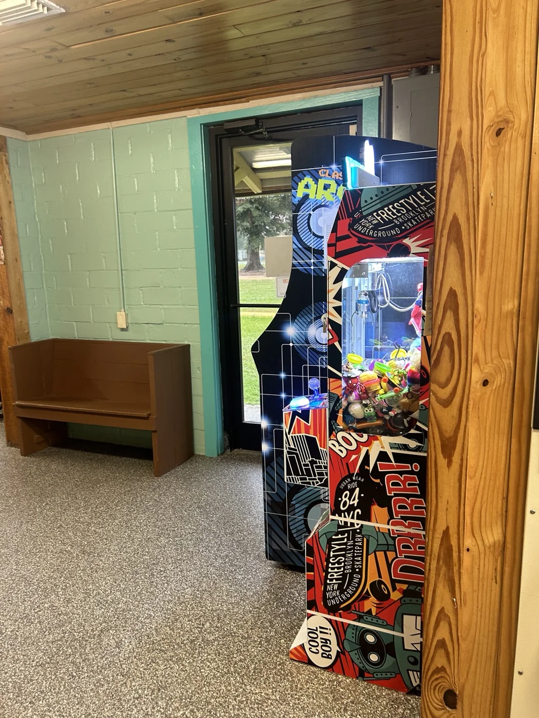 Arcade machine beside an indoor bench